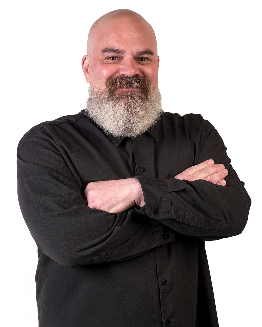 A smiling man with a beard and crossed arms in a black shirt.