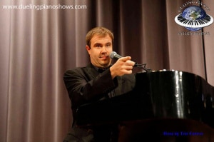 A person performing at a piano on stage.